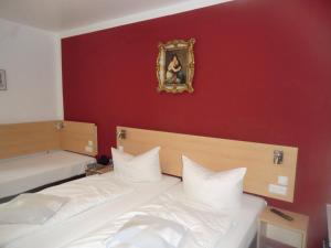 a bedroom with two beds and a painting on the wall at Hotel Pension Haydn in Munich