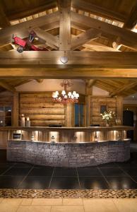 een bar in een gebouw met een houten plafond bij CGH Résidences & Spas Les Granges Du Soleil in La Plagne