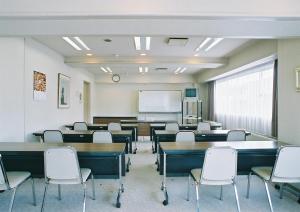 a classroom with tables and chairs and a whiteboard at Tendo Central Hotel in Tendo
