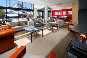 un vestíbulo con sofás, mesas y chimenea en Apartamentos HG Cerler, en Cerler