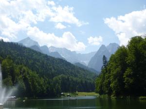 a lake with a waterfall and mountains in the background at Gästehaus Andreas Hofer in Garmisch-Partenkirchen