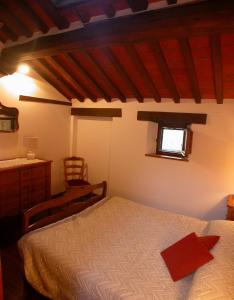 a bedroom with a bed and a dresser and a window at Lauro in Cortona