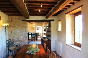a dining room with a table and a stone wall at Scansano Country House in Magliano in Toscana