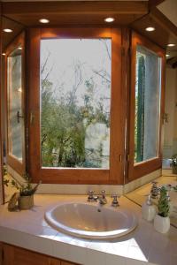 a bathroom with a sink and a large window at Scansano Country House in Magliano in Toscana