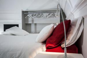 カターニアにあるDomus Claudiaeのベッドルーム(白いベッド、赤い枕付)