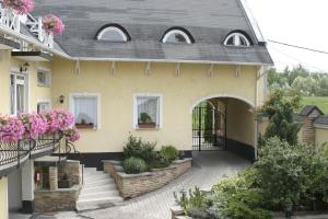 a house with flowers on the side of it at Relax Panzió in Győr