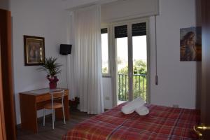 マリーナ・ディ・ラグーザにあるPunta Di Molaのベッドルーム1室(ベッド1台、デスク、窓付)