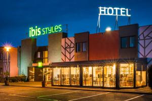 un hôtel avec un panneau en haut dans l'établissement ibis Styles Rouen Val De Reuil, à Val de Reuil