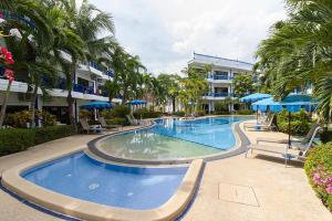 卡馬拉海灘的住宿－The Club Residence Kamala Beach，一座棕榈树大型游泳池和一座建筑