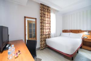 Łóżko lub łóżka w pokoju w obiekcie Petit Palace Preciados