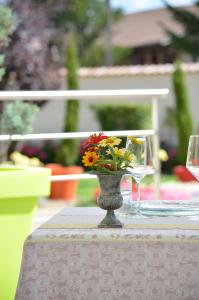 un jarrón con flores sentado sobre una mesa en La Marande, en Montbellet