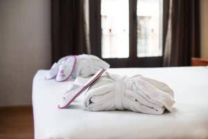 dwa ręczniki na łóżku w obiekcie Petit Palace Preciados w Madrycie