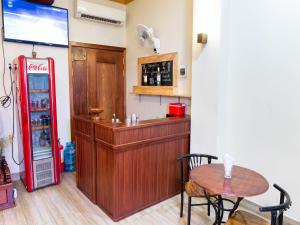 ein Restaurant mit einem roten Kühlschrank und einem Tisch in der Unterkunft Dynsey Boutique Hotel in Phnom Penh