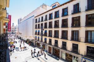 a group of people walking on a street in front of a building at Petit Palace Preciados in Madrid