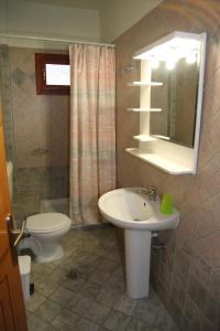 a bathroom with a sink and a toilet and a mirror at Vaya Apartments & Studios in Platamonas +44 photos