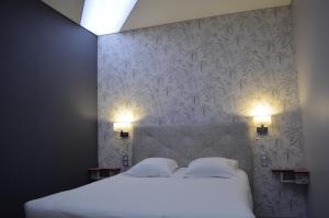 a bedroom with a large white bed with two pillows at La Marande in Montbellet