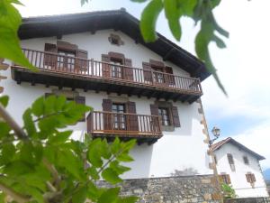 un edificio blanco con balcones de madera en Matxingonea I y II, en Zozaia