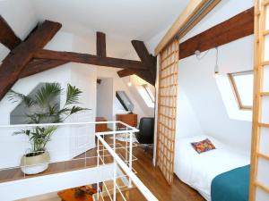 a room with white walls and wooden beams at Folk Loft in Annecy