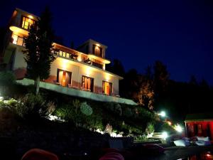 a large white house with its lights on at night at Serenity Boutique Suites in Athani