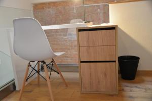 a white chair sitting next to a wooden cabinet at Maison am Liesingbach in Vienna