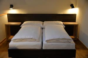 a bed with three pillows on it with two lights at Maison am Liesingbach in Vienna