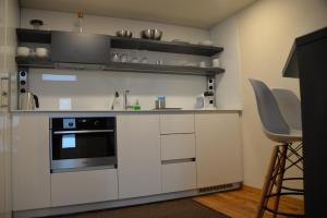 a kitchen with white cabinets and a stove at Maison am Liesingbach in Vienna