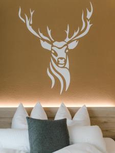 a stenciled deer head on a wall above a bed at Schlemmerhütte - Hotel in Langweid