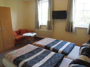 a hotel room with two beds and a couch at Domäne Paterhof in Duderstadt