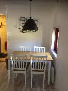 a dining room table with four chairs and a chandelier at Klitterbyn Lodge in Ängelholm