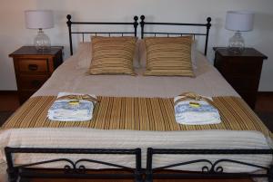 uma cama com duas toalhas e duas l�mpadas em Casa do Ch�o do Ribeiro em Gouveia mais 37 fotografias