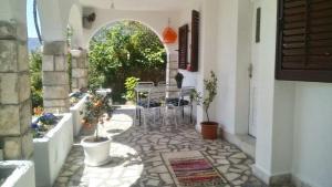 a patio with a table and chairs in a building at House Orange Apartments in Herceg-Novi
