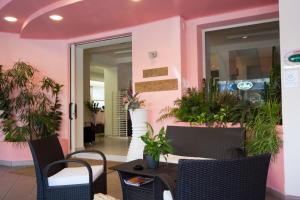 a table and chairs in a restaurant with pink walls at Hotel Myosotis in Riccione