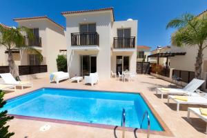una villa con piscina di fronte a una casa di Casa Di Kappari a Protaras