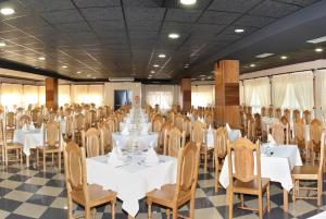 a banquet hall with white tables and chairs at Hotel Pedramar in A Lanzada