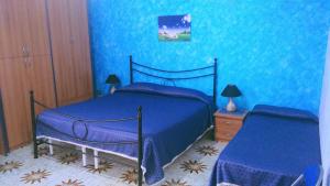a blue bedroom with a bed and a night stand at Antica Dimora Marinelli in Ficarra +9 photos