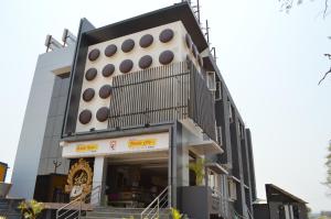 a large building with a store front with at Temple City Hotels India Pvt. Ltd in Cholavandān