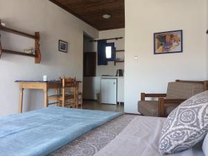 sypialnia z łóżkiem i stołem oraz kuchnia w obiekcie Egeon Studios w mieście Neos Marmaras