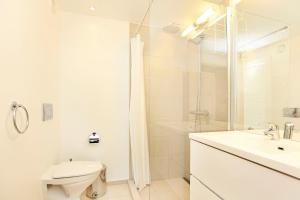 CPH Lux apartm, 2 FULL BATHROOMS 2th في كوبنهاغن: حمام ابيض مع مرحاض ومغسلة
