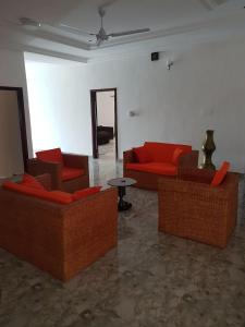 una sala de estar con sofás rojos y una mesa. en Nana's Holiday Let, en Accra