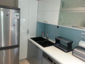 a kitchen with a sink and a refrigerator at Apartments Roncevic in Zadar