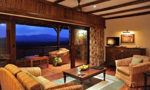 un soggiorno con divano, sedie e TV di Kilaguni Serena Safari Lodge a Tsavo