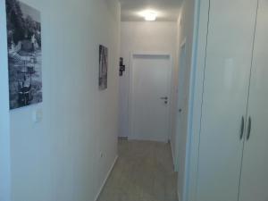 a hallway with a white door and a cross on the wall at Apartments Roncevic in Zadar