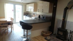 a kitchen with a stove and a kitchen with a table at Lord Byron Lodge in Blidworth