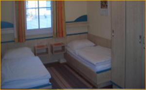 um pequeno quarto com 2 camas e uma janela em Gasthof Schlosswirt em Klagenfurt