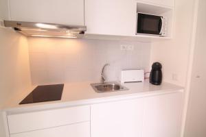 uma pequena cozinha com um lavatório e um micro-ondas em Páteo Saudade Lofts Marquês em Lisboa