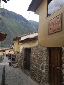 una calle en un pueblo en las montañas en Rumi Sonqo Hostel, en Ollantaytambo