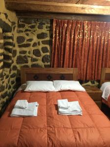1 dormitorio con 1 cama con toallas en Rumi Sonqo Hostel, en Ollantaytambo