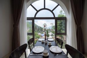 a table in a room with a large window at Sapa Wings Hotel in Sapa