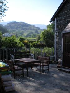 a patio with a table and benches and a building at The Black Bull Inn and Hotel in Coniston