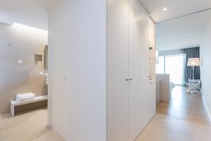 a room with white walls and a hallway at Palmares Beach House Hotel - Adults Only in Lagos